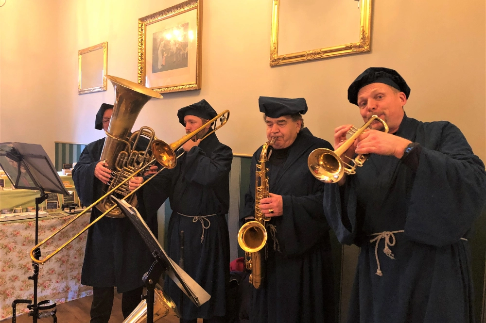 Blaskapelle Thüringen Gruppenfoto outdoor. Musiker mit Trompete, Klarinette, Akkordeon und Tuba bei einer Blasmusik-Impression im Grünen.