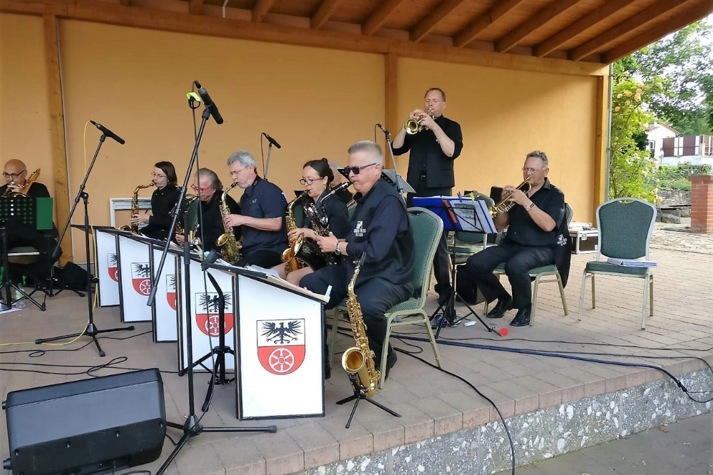 Open-Air Bühne Thüringen. Bigband/Blaskapelle mit Saxofonen und Trompeten bei einem Auftritt unter freiem Himmel.